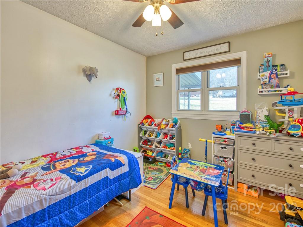 970 Ratcliff Cove Road Waynesville, NC 28786 - Photo 20 of 24 a bedroom with a bed and a wooden floor