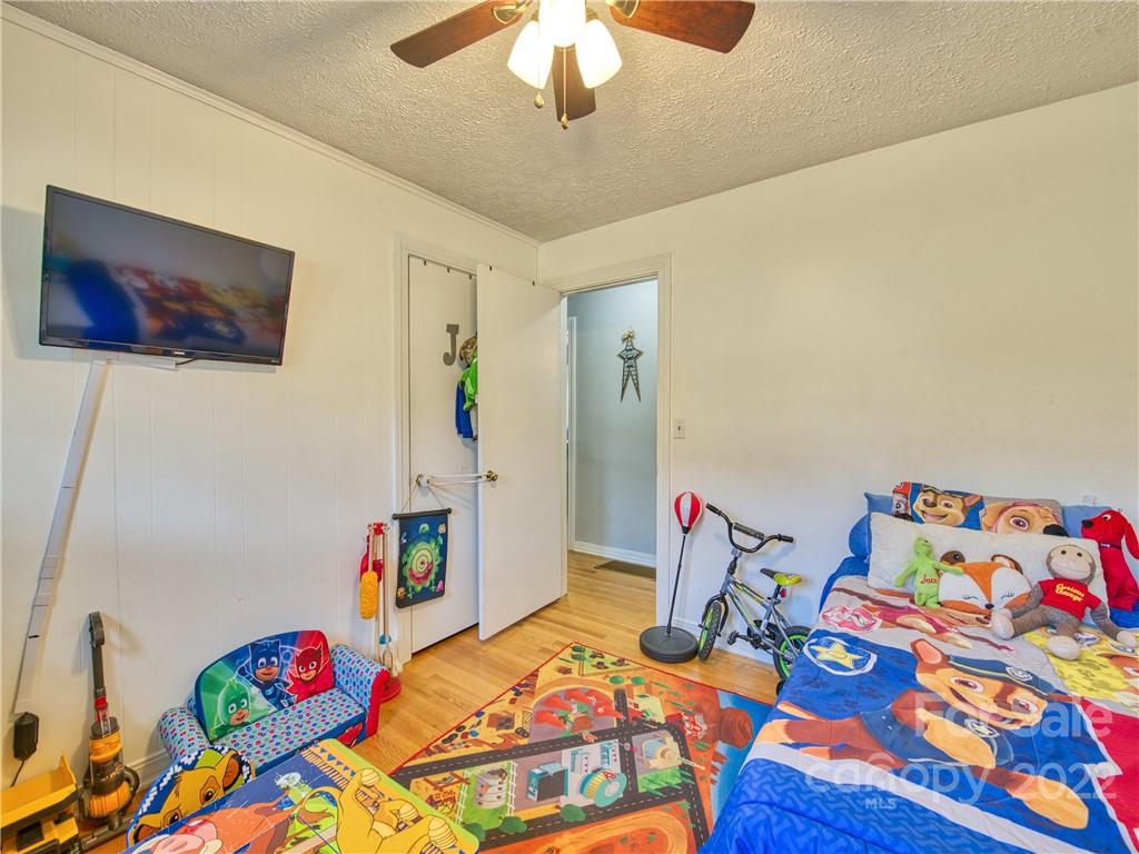 970 Ratcliff Cove Road Waynesville, NC 28786 - Photo 21 of 24 a bedroom with a bed and a chandelier