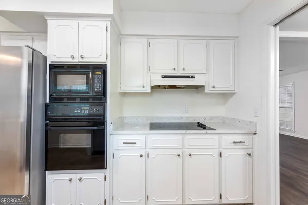 a kitchen with white cabinets and stainless steel appliances