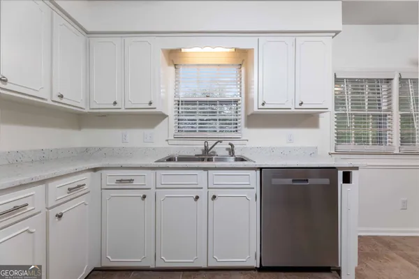 a kitchen with cabinets appliances a sink and a window
