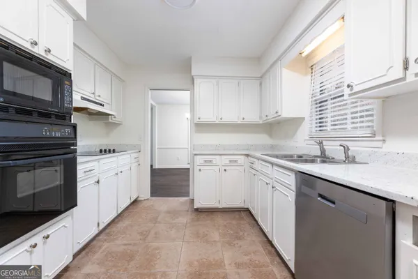 a kitchen with granite countertop cabinets stainless steel appliances a sink and a window