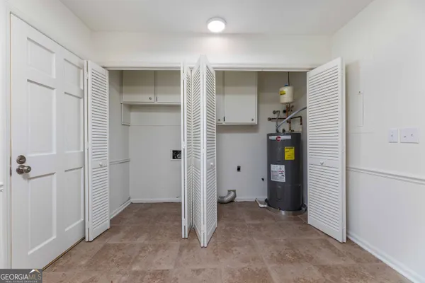 a view of an empty room with closet and a window