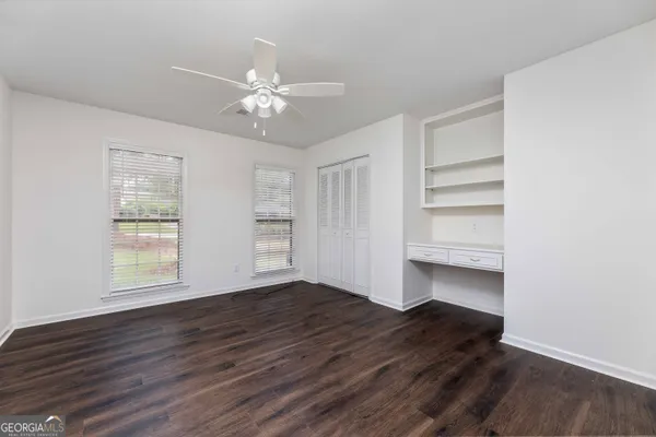 a view of a room with wooden floor and ceiling fan