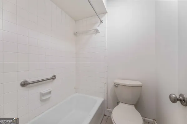 a white toilet sitting next to a bath tub