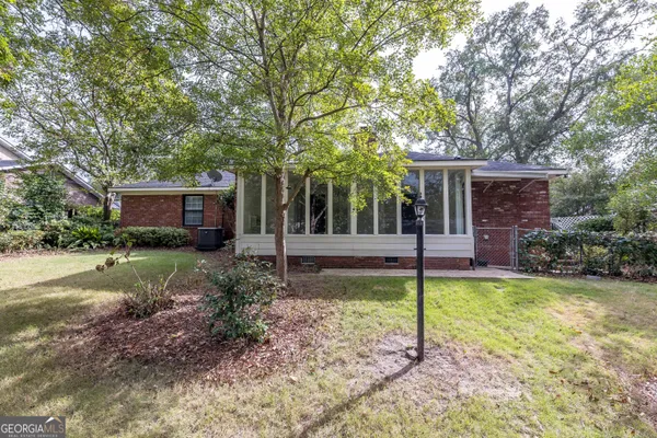 a view of a house with backyard and a tree