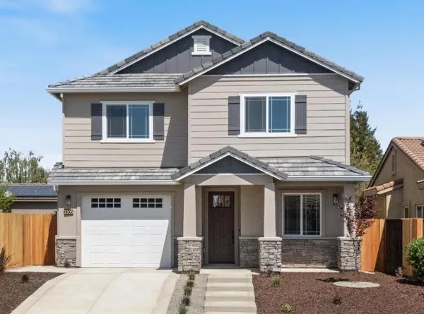 a front view of a house with a yard outdoor seating and garage
