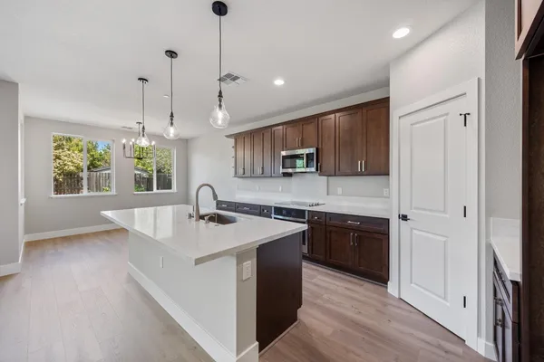 a kitchen with stainless steel appliances granite countertop a sink a microwave cabinets and a window