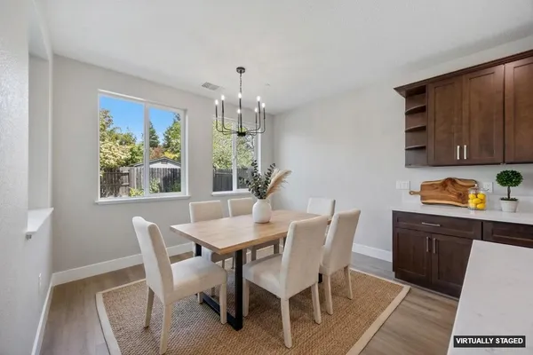 a living room with furniture kitchen view and a chandelier