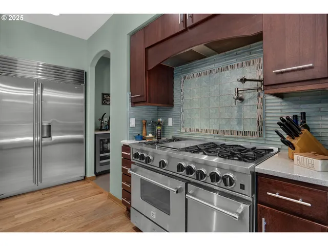 a kitchen with stainless steel appliances granite countertop a stove and a refrigerator