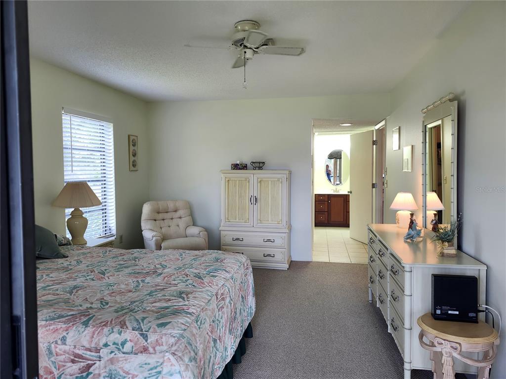 4260 Placida Road, Unit 21D Englewood, FL 34224 - Photo 19 of 38 a bedroom with a bed and a chandelier