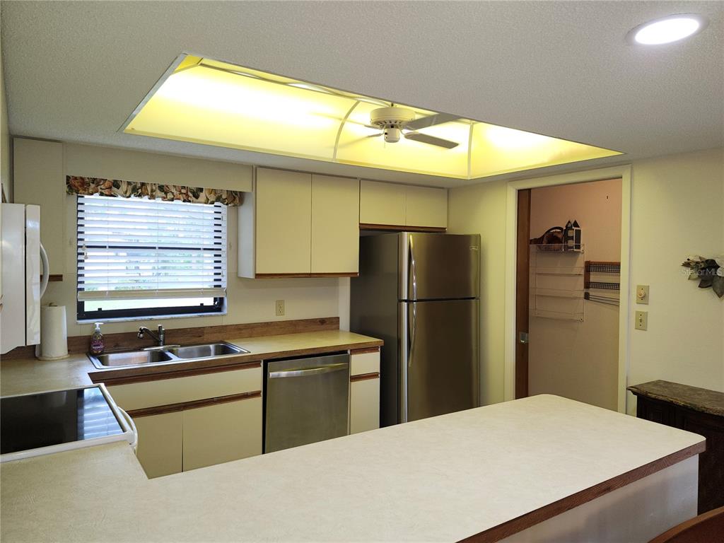 4260 Placida Road, Unit 21D Englewood, FL 34224 - Photo 8 of 38 a kitchen with stainless steel appliances kitchen island a refrigerator sink and stove