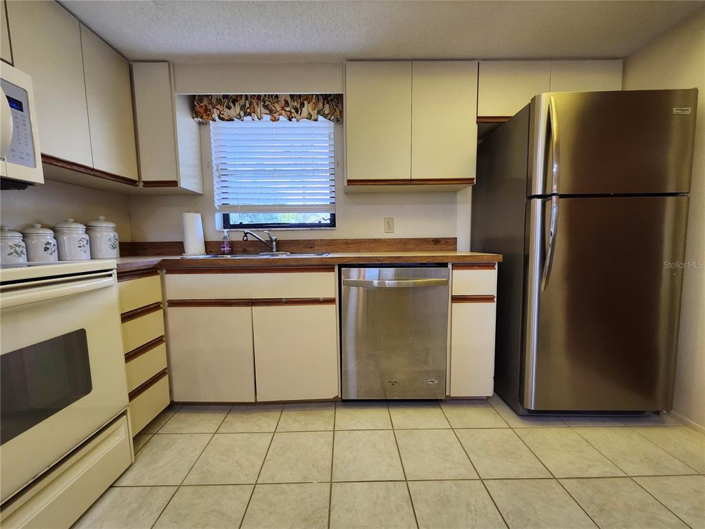 4260 Placida Road, Unit 21D Englewood, FL 34224 - Photo 9 of 38 a kitchen with cabinets a refrigerator and a sink