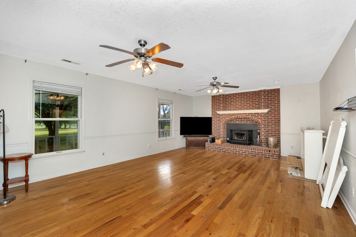 81 Slaughter Pen Road Ardmore, TN 38449 - Photo 3 of 63 a view of a livingroom with wooden floor and a fireplace