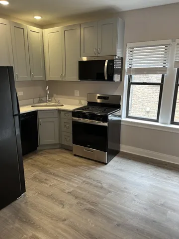 a kitchen with stainless steel appliances granite countertop a stove a sink and a microwave