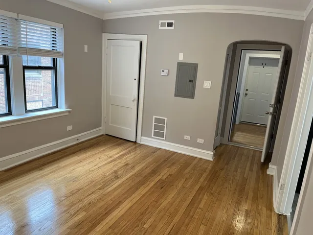 an empty room with wooden floor and a window