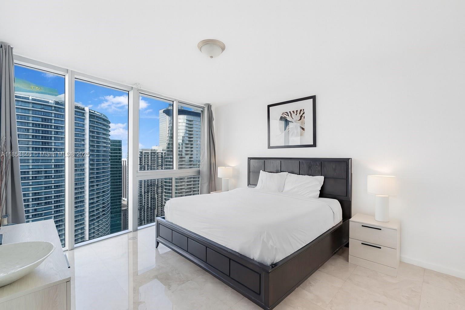 485 Brickell Avenue, Unit 4404 Miami, FL 33131 - Photo 6 of 14 a large bed sitting in a bedroom next to a large window
