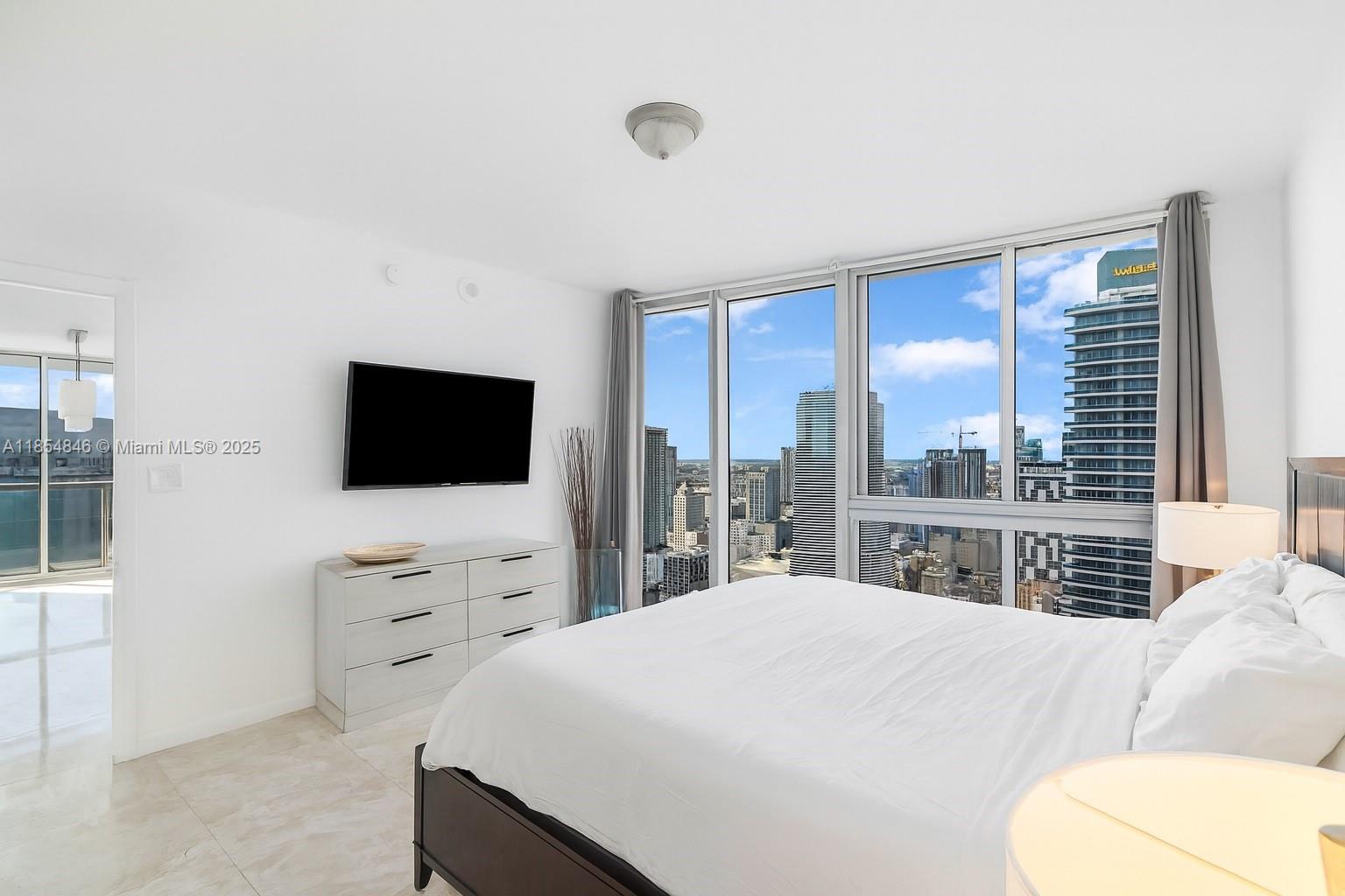 485 Brickell Avenue, Unit 4404 Miami, FL 33131 - Photo 7 of 14 a bedroom with a large bed and a flat screen tv