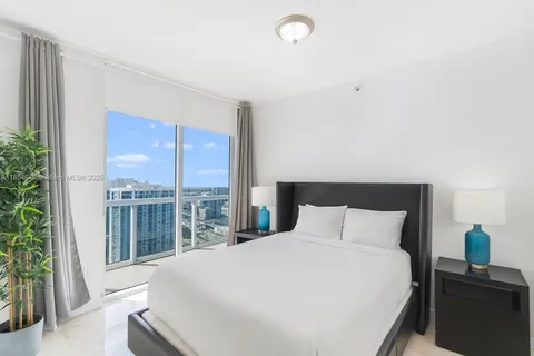 a bedroom with a large window and a bed