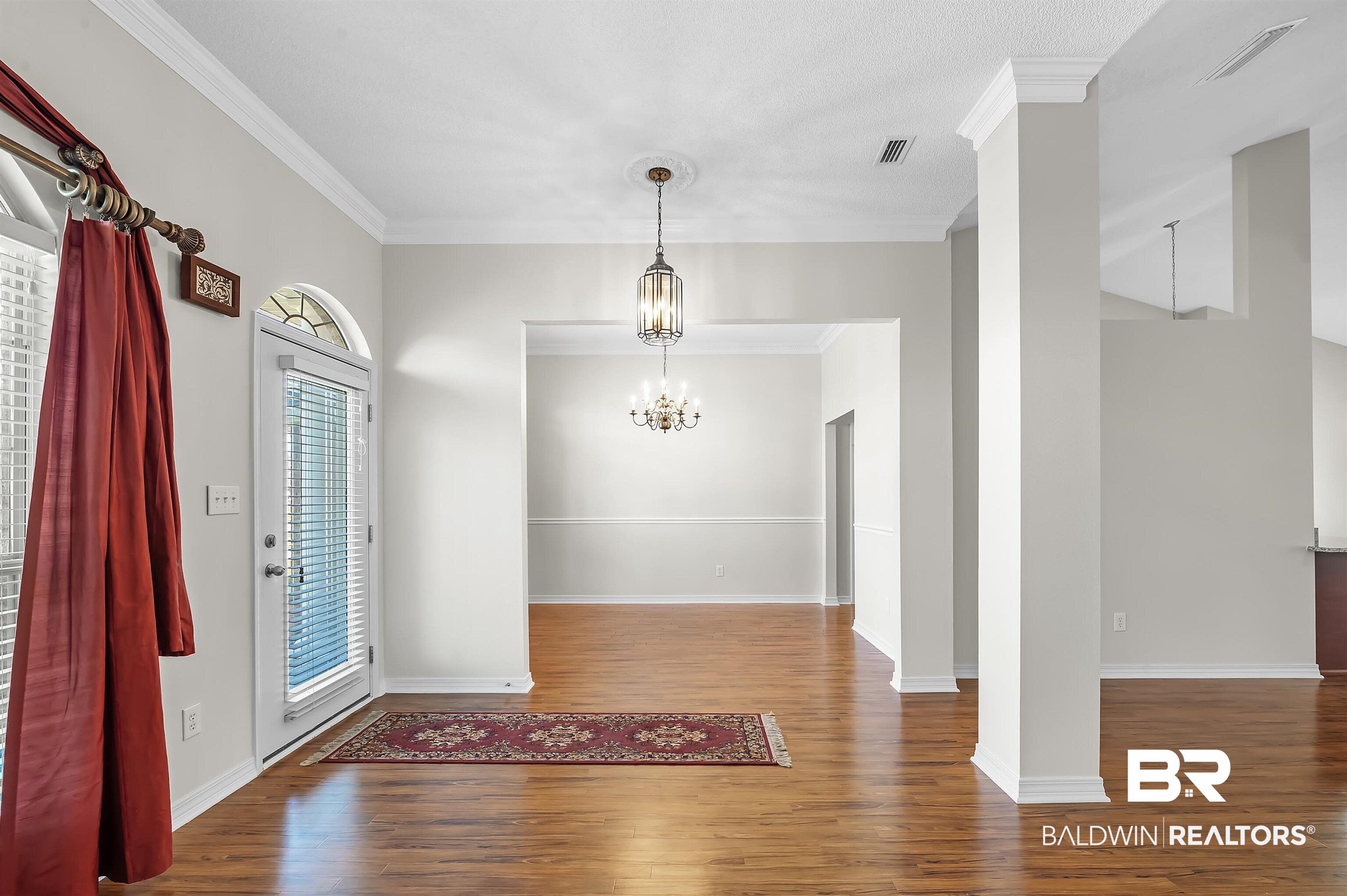 421 Collinwood Loop Foley, AL 36535 - Photo 16 of 62 Entryway with ornamental molding, a chandelier, hardwood / wood-style flooring, and decorative columns