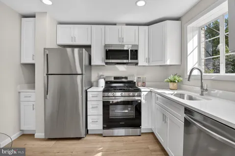 a kitchen with cabinets stainless steel appliances and a sink
