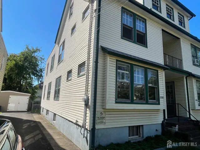 a view of a house with a yard and wooden fence