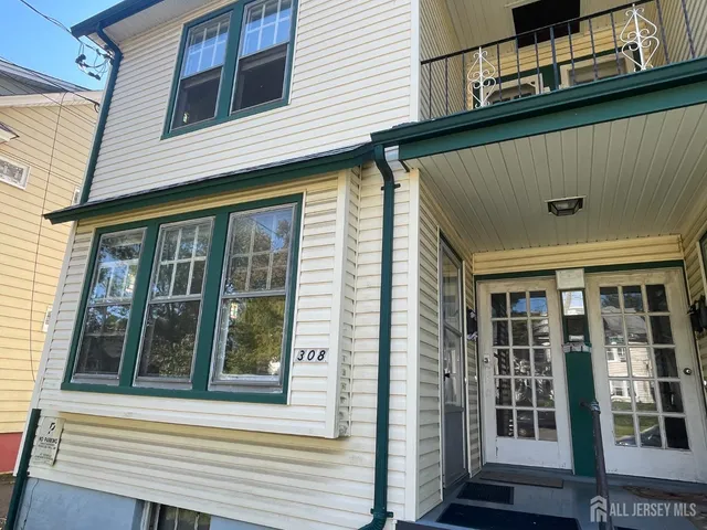 a view of a house with a door and wooden bench