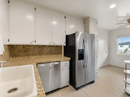 a kitchen with stainless steel appliances granite countertop a refrigerator a stove and a sink
