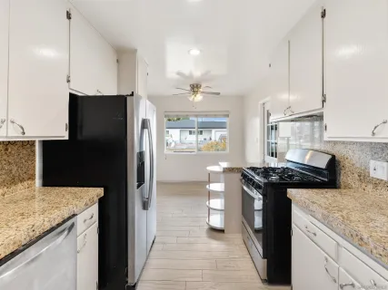 a kitchen with granite countertop a stove and a refrigerator