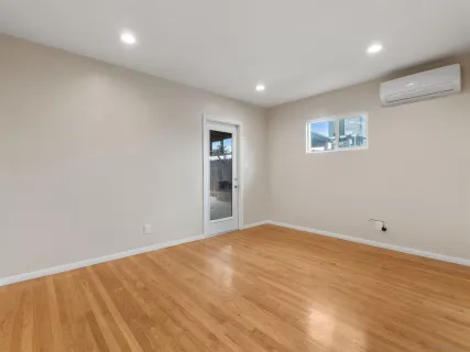a view of an empty room with wooden floor
