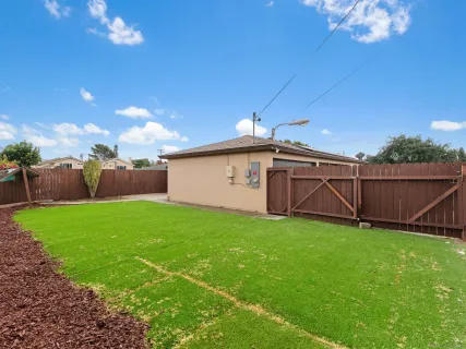 a view of a house with backyard and trees