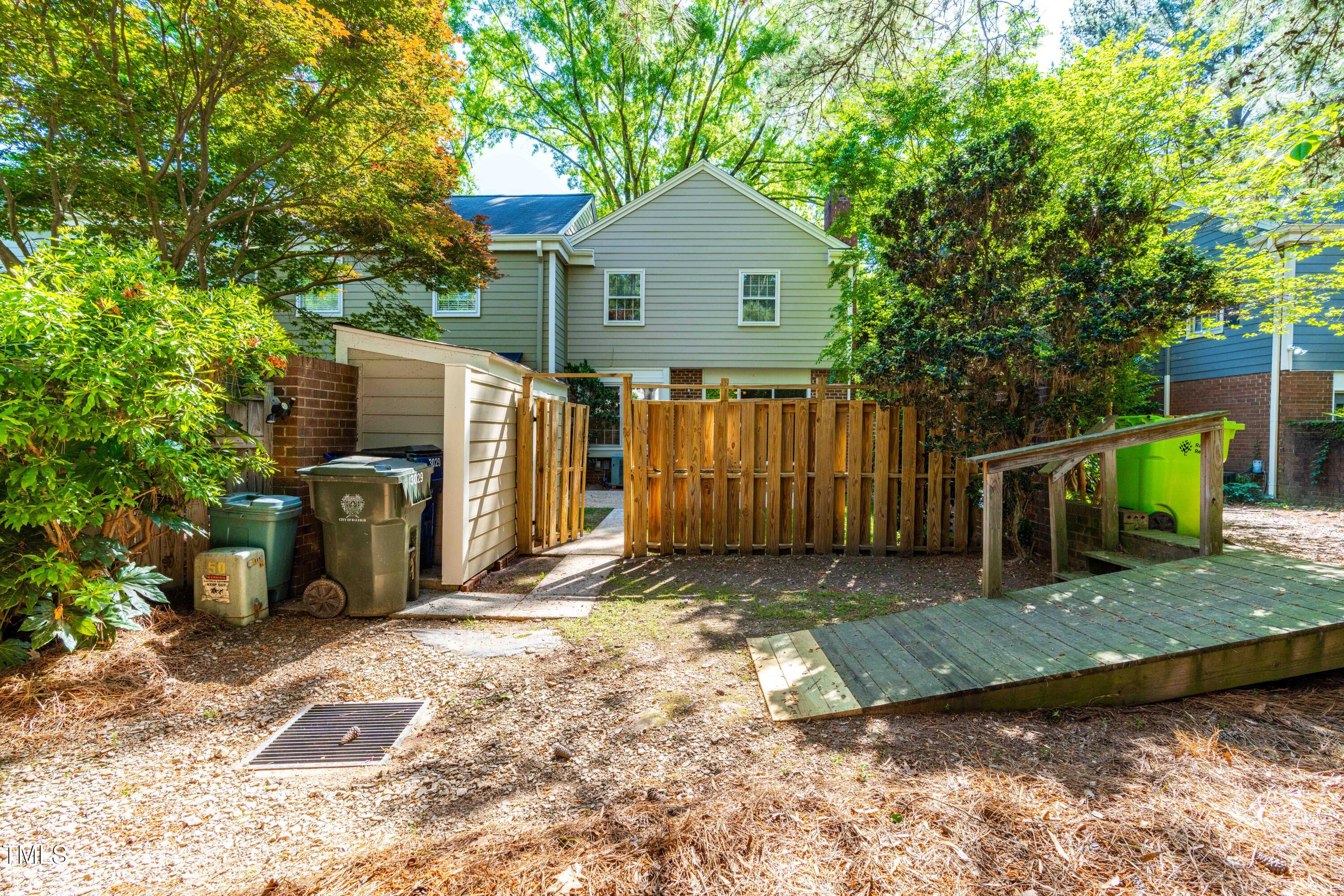 3029 Wycliff Road Raleigh, NC 27607 - Photo 32 of 35 a view of a backyard with wooden fence and large trees
