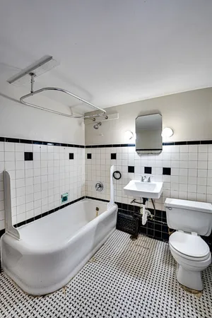 a bathroom with a bathtub sink mirror and toilet