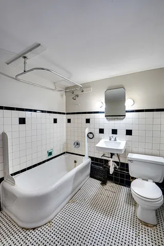 a bathroom with a bathtub sink mirror and toilet