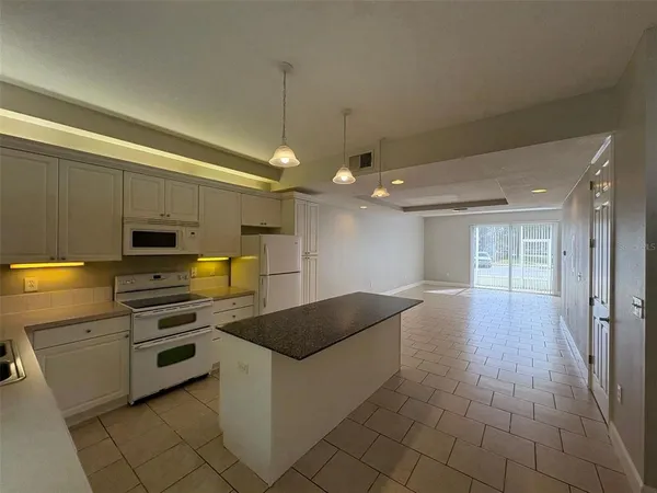 a kitchen with granite countertop a stove and a sink
