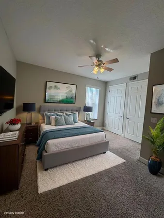a spacious bedroom with a bed and a chandelier