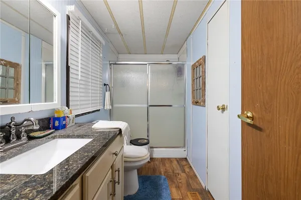 a bathroom with a granite countertop sink toilet and shower