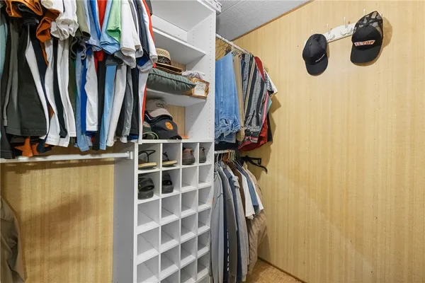 a view of walk in closet with clothes and shoes