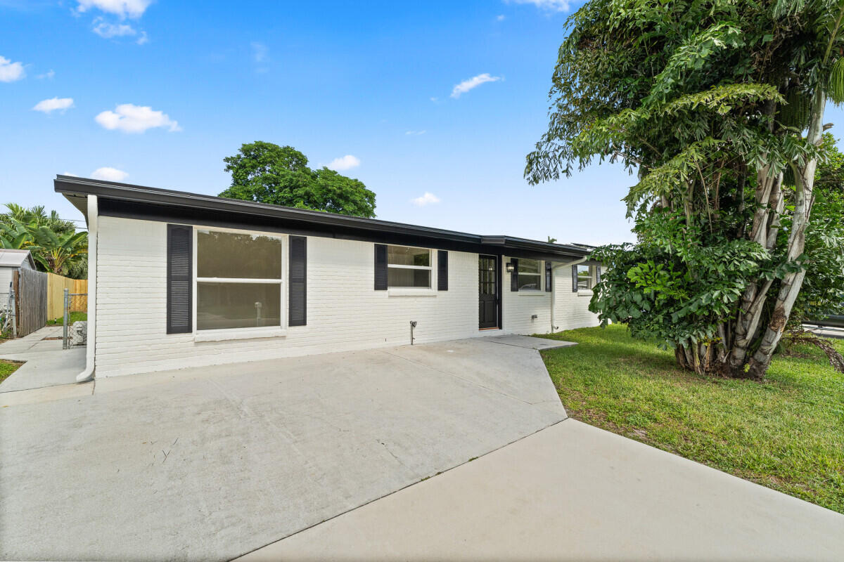3797 Bahama Road Palm Beach Gardens, FL 33410 - Photo 28 of 33 front view of a house with a yard