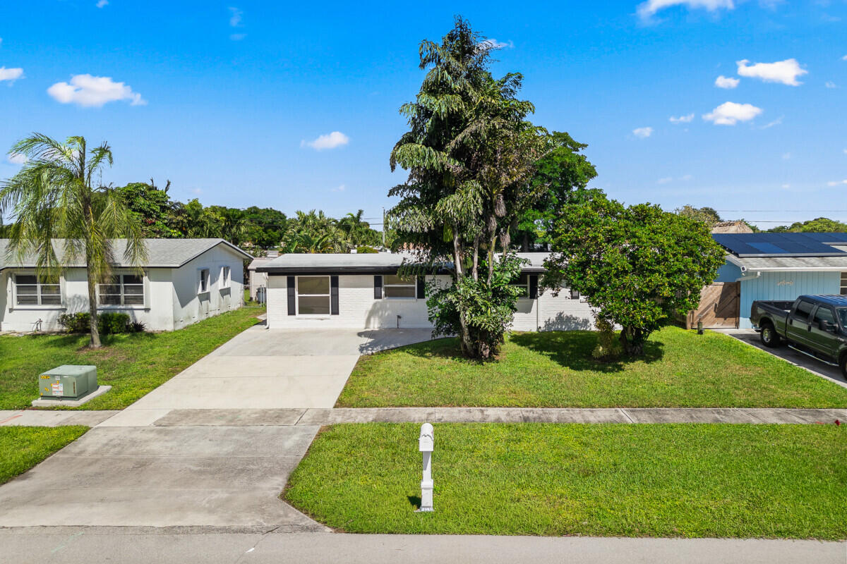 3797 Bahama Road Palm Beach Gardens, FL 33410 - Photo 29 of 33 a front view of a house with a yard