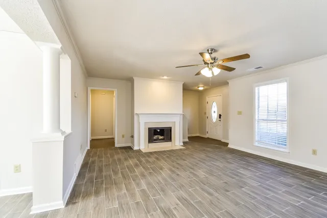 an empty room with windows and fireplace