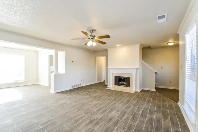 wooden floor fireplace and windows in an empty room