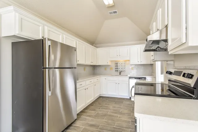 a kitchen with stainless steel appliances granite countertop a refrigerator sink and cabinets