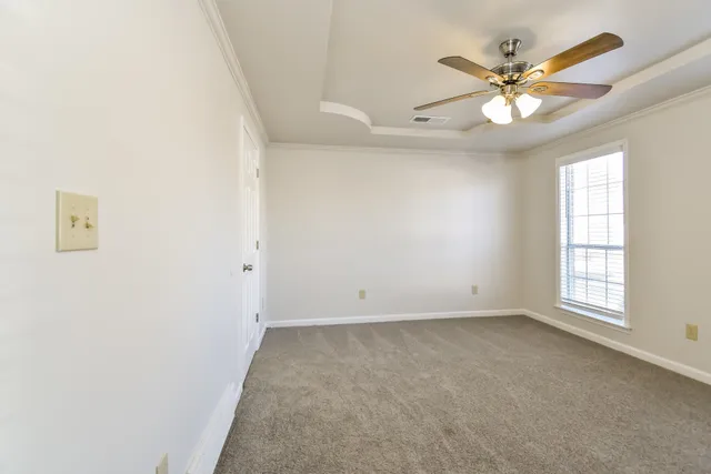 an empty room with windows and fan