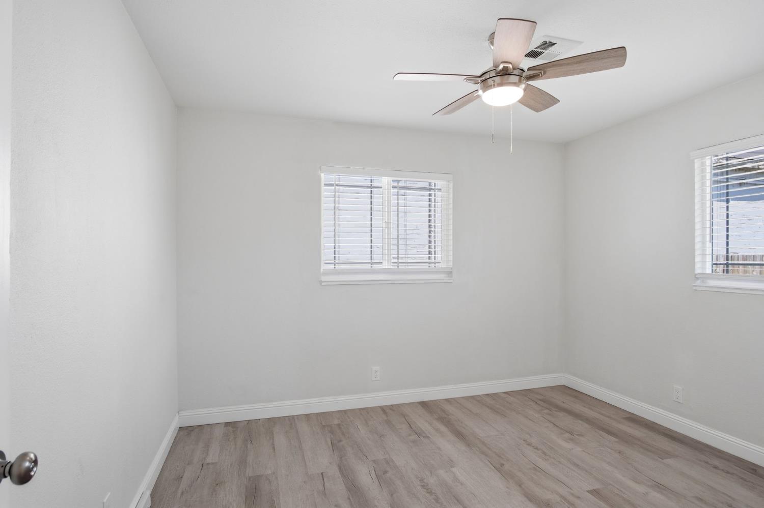 341 2nd Street Livingston, CA 95334 - Photo 14 of 19 an empty room with wooden floor ceiling fan and windows