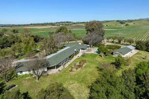 an aerial view of a house with swimming pool and garden