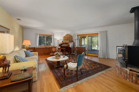 a dining room with furniture large windows and wooden floor