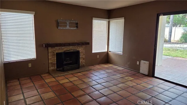a view of an empty room with window and fire place