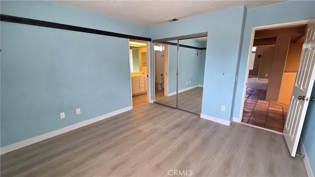 a view of empty room with wooden floor and window