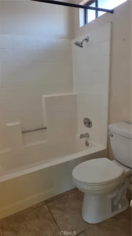 a white toilet sitting next to a bath tub