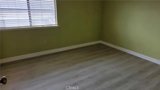 a view of a room with wooden floor and a window